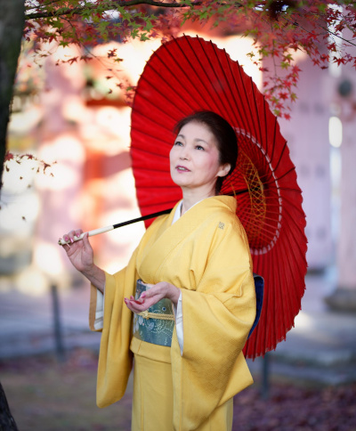 FullmyBijin Academy (ふる舞い美人アカデミー)投稿のヒーロー画像 創業者の桜川舞は、若狭傘を持ち、金色の着物を着ています。